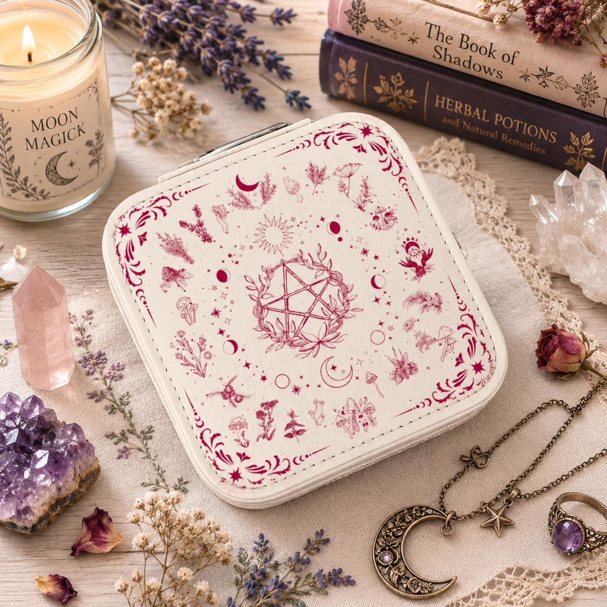 Angled view of a black floral pentagram jewelry box beside a candle and botanical books.