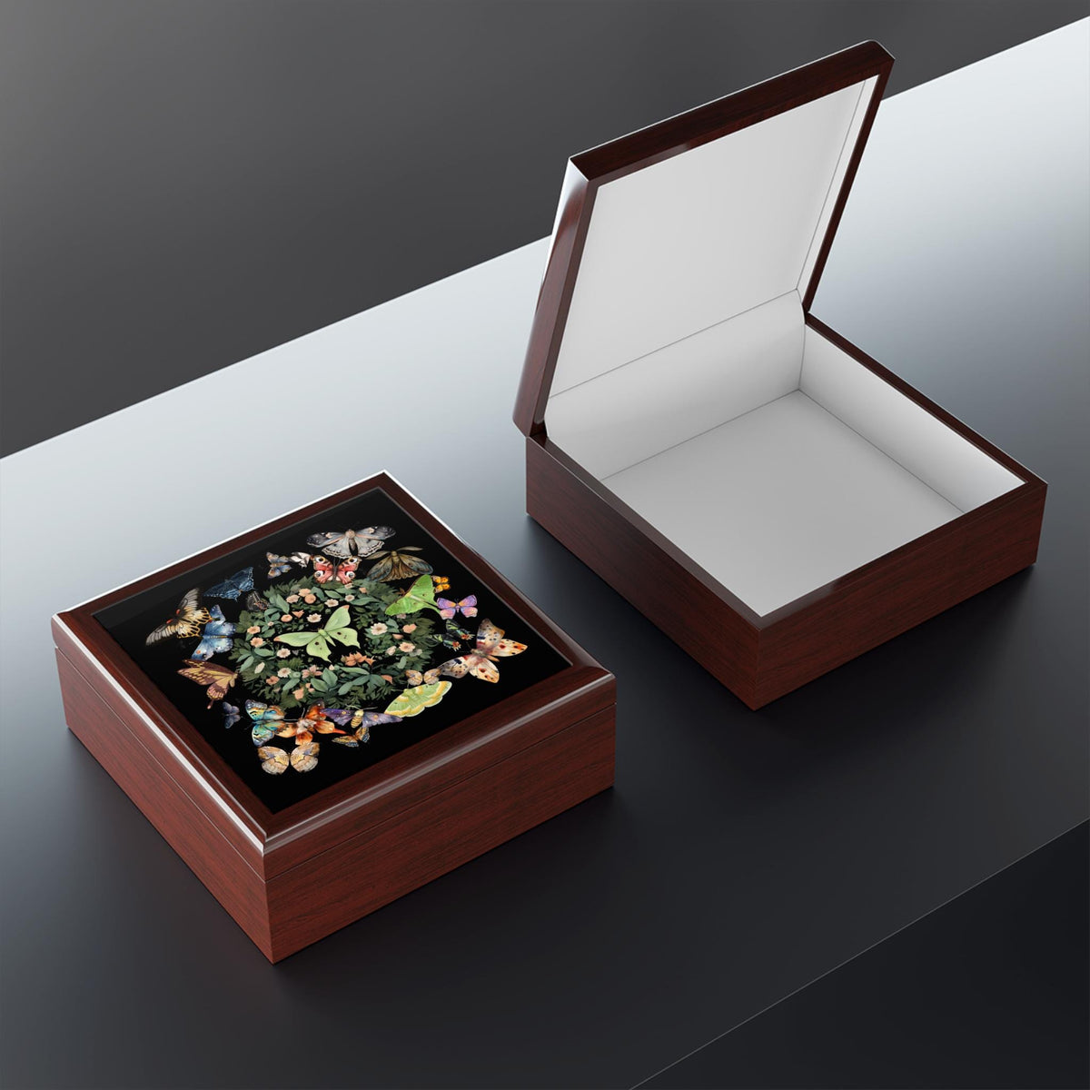 Open and closed brown luna moth jewelry boxes viewed at an angle on a dark tabletop.