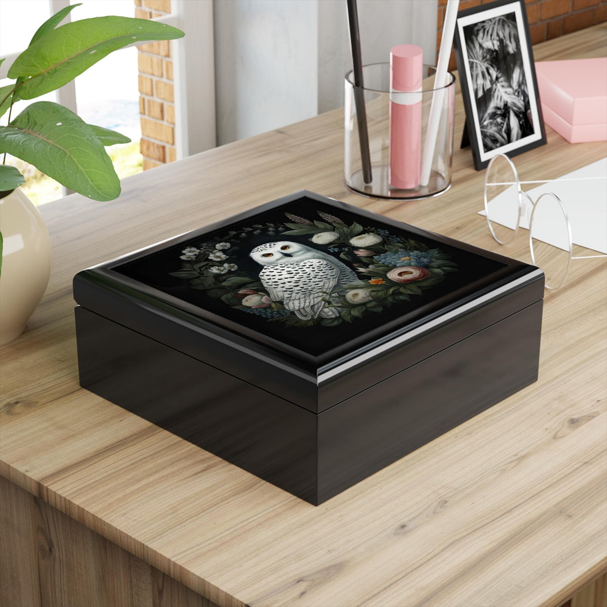 Top view of a brown jewelry box lid featuring a white owl among flowers on a black background.