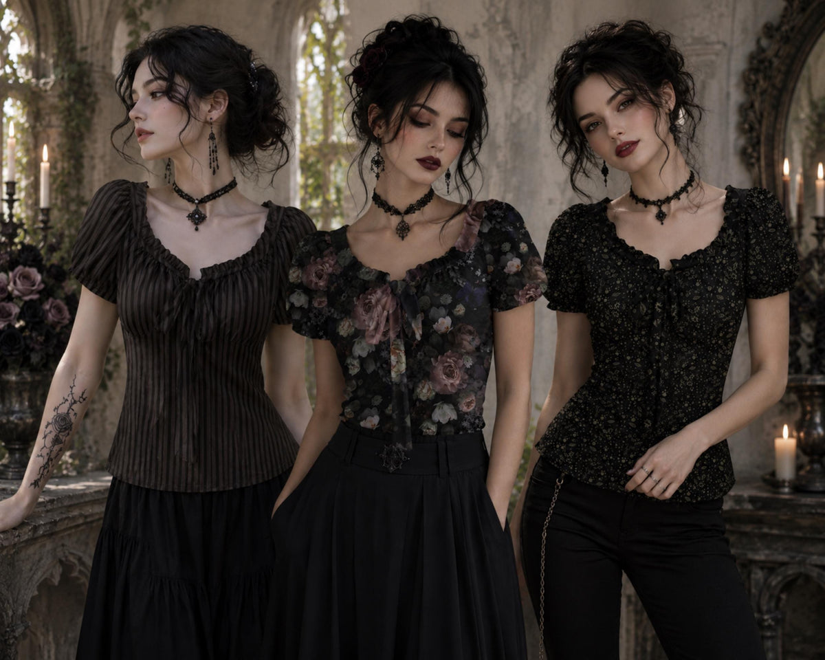 Three women pose in gothic-style clothing in an ornate, candle-lit interior. The outfits include a dark brown pleated top with a black skirt, a floral black short-sleeve top with a black skirt, and a black sequined top with black pants.