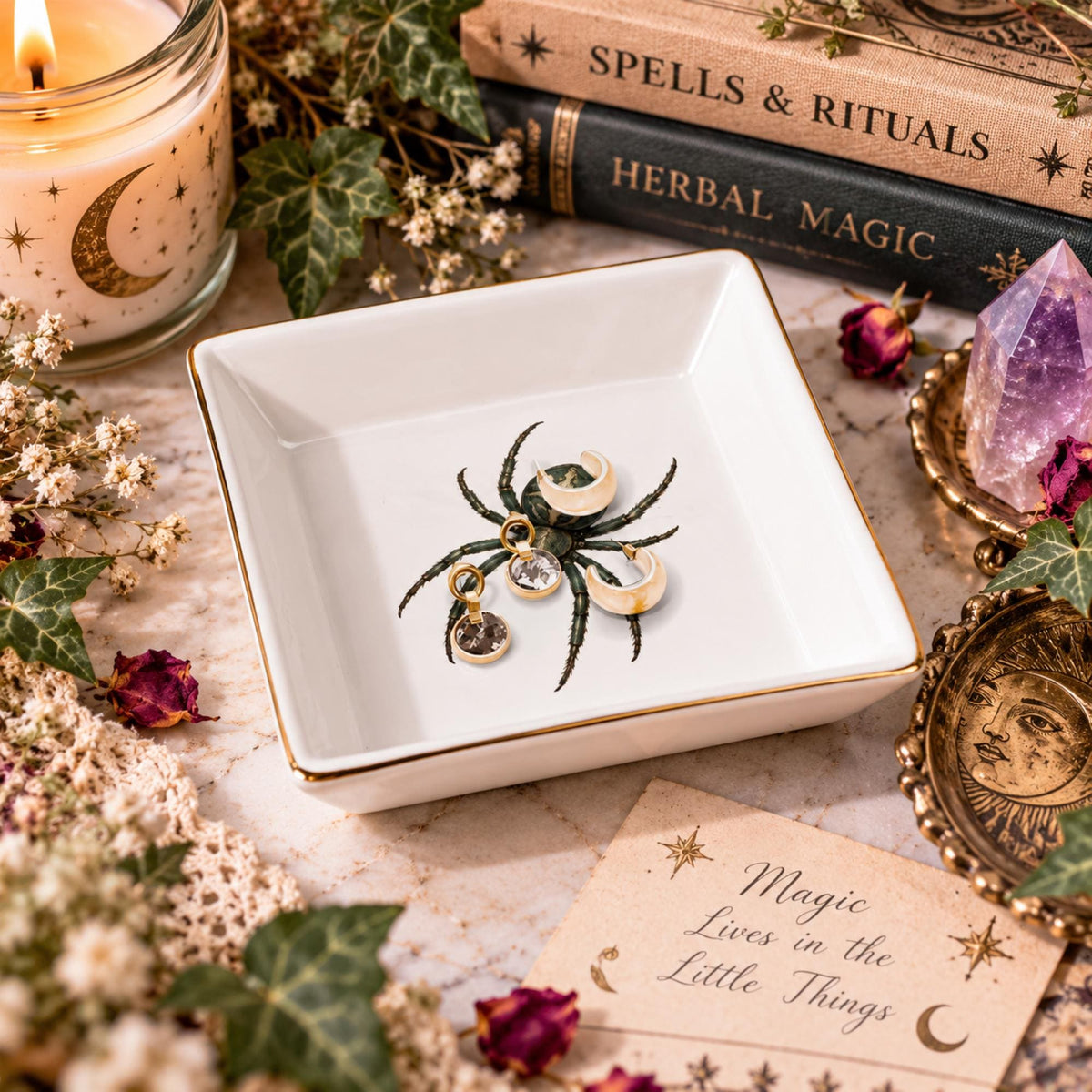 Angled view of a white gold-rimmed spider jewelry dish holding crescent earrings and small gemstone pendants.